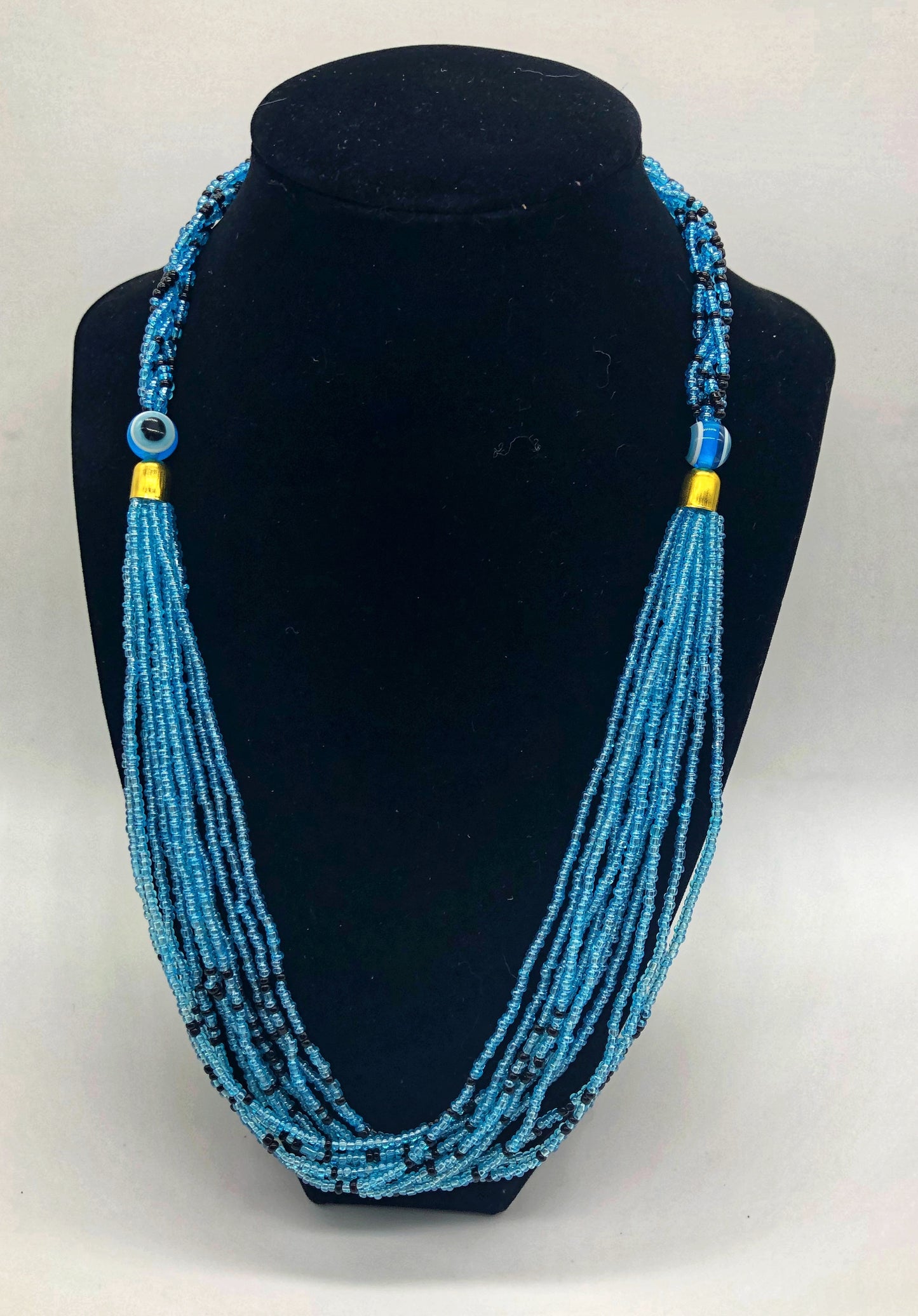 The Dinah necklace is named after one of our ladies whose photo you will find within this collection. The Dinah is a Fair trade hand crafted colorful seed bead necklace. It is very delicate and classy. Each necklace contains braided beads at top flowing into colorful hanging beads on the bottom. Each necklaces had solid color beads which are combined with colorful accent bead embellishment. Slip over neck or easy open/close.