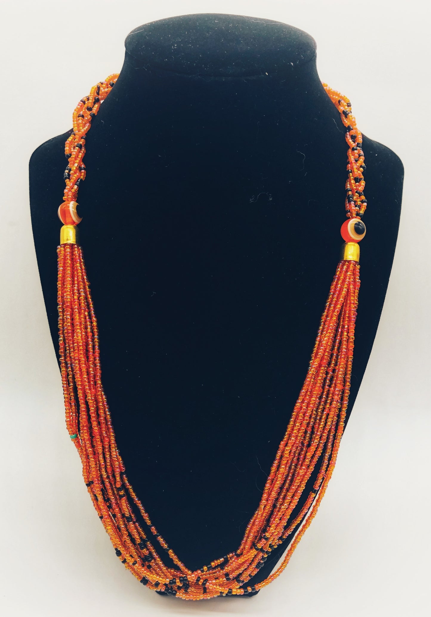 The Dinah necklace is named after one of our ladies whose photo you will find within this collection. The Dinah is a Fair trade hand crafted colorful seed bead necklace. It is very delicate and classy. Each necklace contains braided beads at top flowing into colorful hanging beads on the bottom. Each necklaces had solid color beads which are combined with colorful accent bead embellishment. Slip over neck or easy open/close. Orange color with black accent.