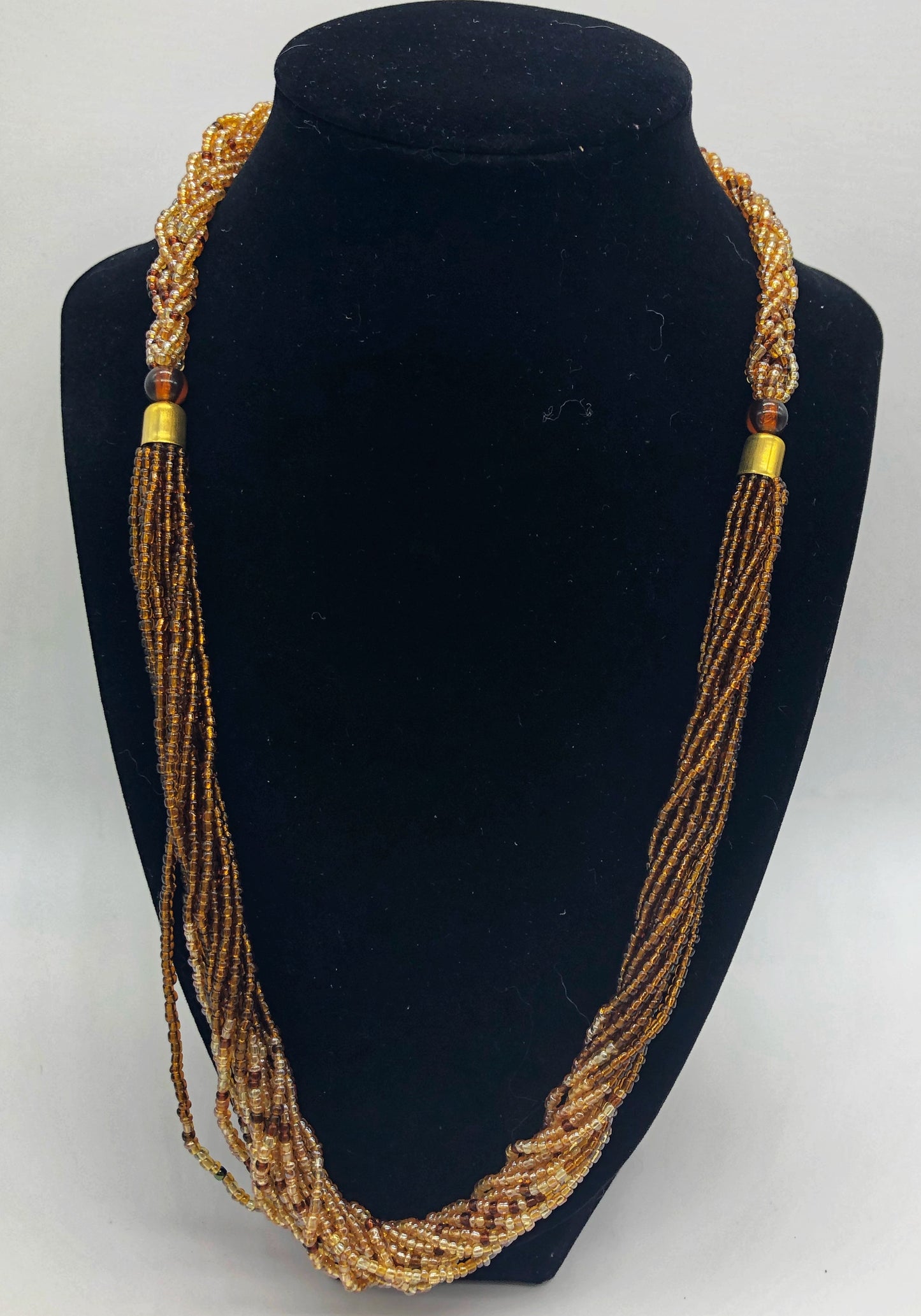 The Dinah necklace is named after one of our ladies whose photo you will find within this collection. The Dinah is a Fair trade hand crafted colorful seed bead necklace. It is very delicate and classy. Each necklace contains braided beads at top flowing into colorful hanging beads on the bottom. Each necklaces had solid color beads which are combined with colorful accent bead embellishment. Slip over neck or easy open/close. brown and tan iridescent