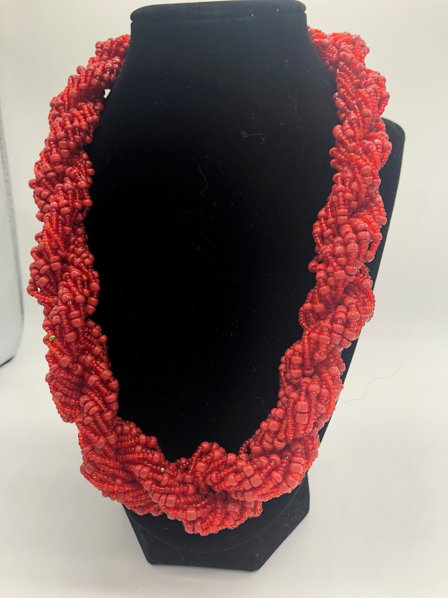 Stand out in style with this beautiful hand made braided style beaded necklace. Approximately 18" end to end. The Dorcas necklace is named after one of our ladies whose photo you will find within this collection. Red