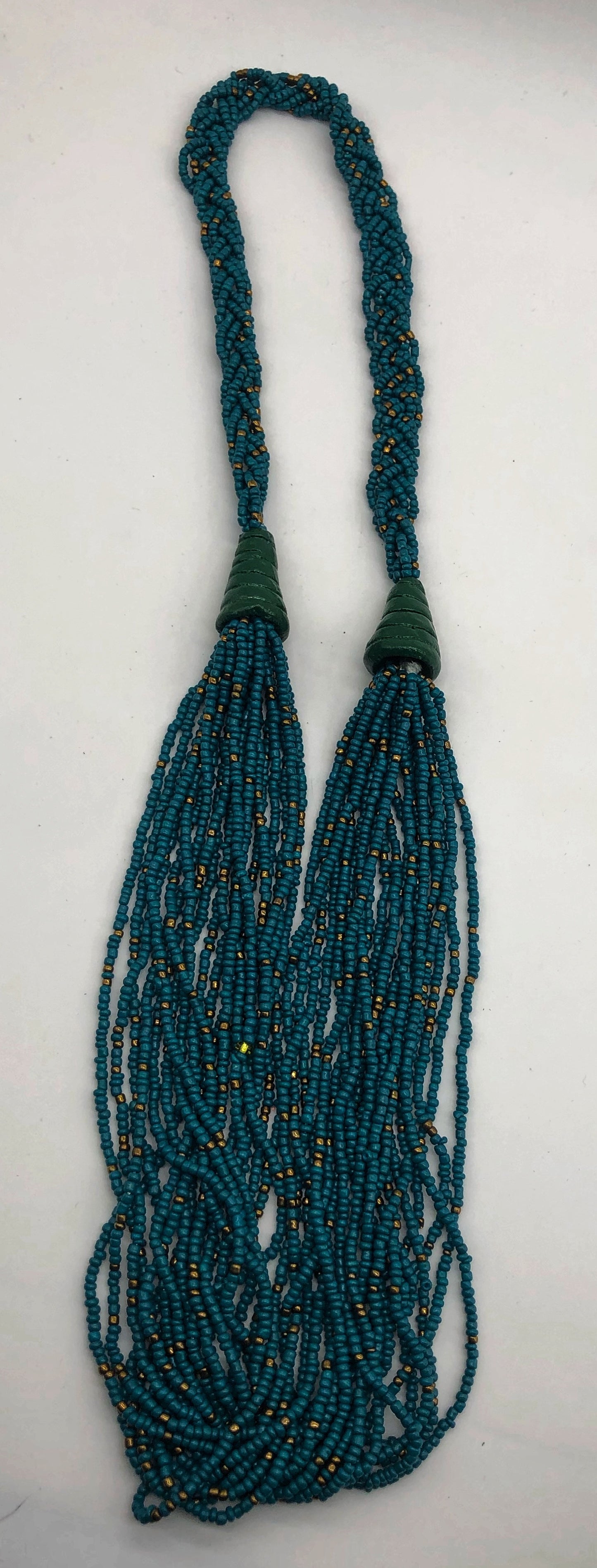 Make a statement with this beautiful handmade seed bead necklace. Styled with braided beads around the neck flowing into a loose styled design. Teal with gold bead accent