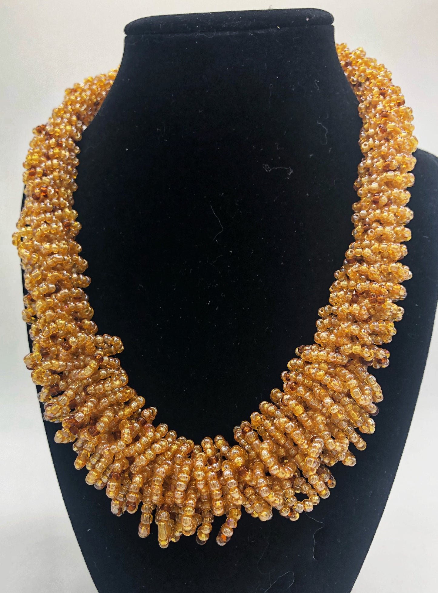 Stand out in style with this beautiful handmade loop bead style necklace. Hover over the photo to see the detail of how the beads are made into a loop design. Thoughtfully designed for style and stand out fashion. Approximately 18" end to end. light gold