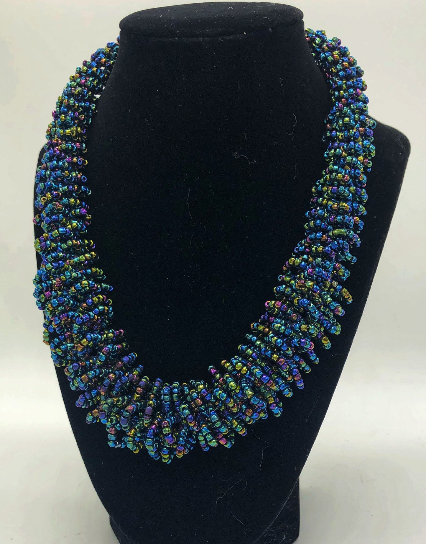 Stand out in style with this beautiful handmade loop bead style necklace. Hover over the photo to see the detail of how the beads are made into a loop design. Thoughtfully designed for style and stand out fashion. Approximately 18" end to end. slate blue multi