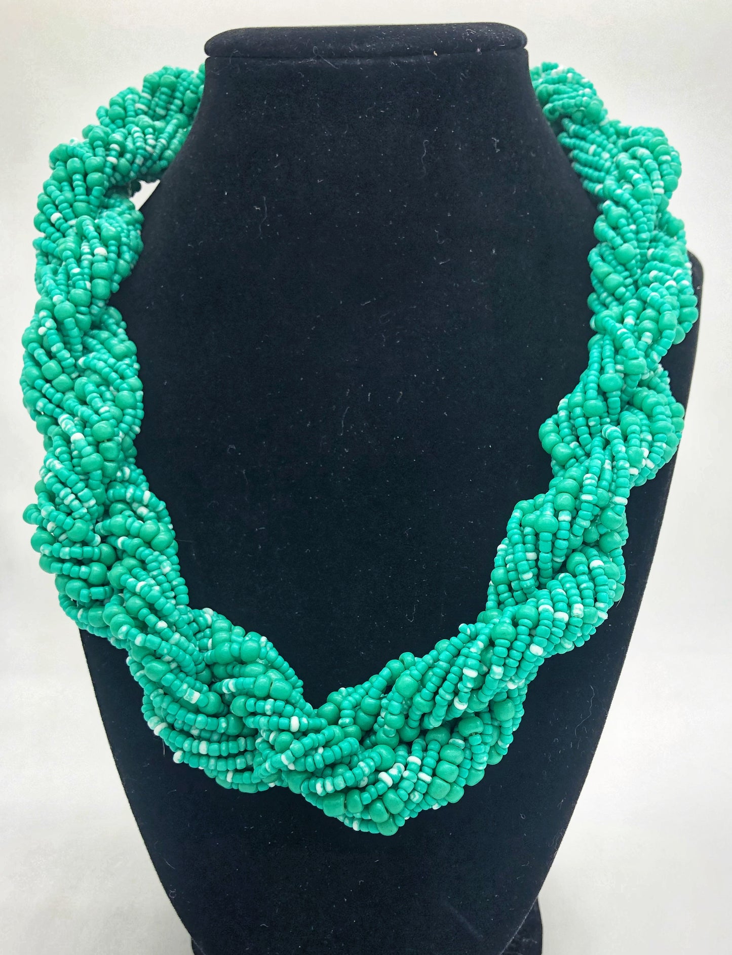 Stand out in style with this beautiful hand made braided style beaded necklace. Approximately 18" end to end. The Dorcas necklace is named after one of our ladies whose photo you will find within this collection. Aqua