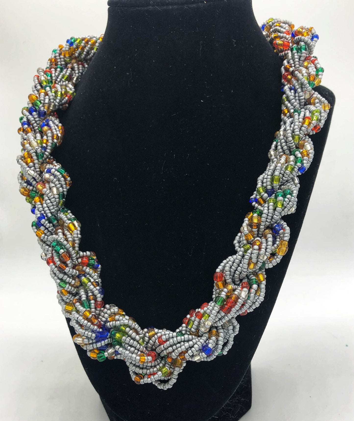 Stand out in style with this beautiful hand made braided style beaded necklace. Approximately 18" end to end. The Dorcas necklace is named after one of our ladies whose photo you will find within this collection. Silver with multicolor accent