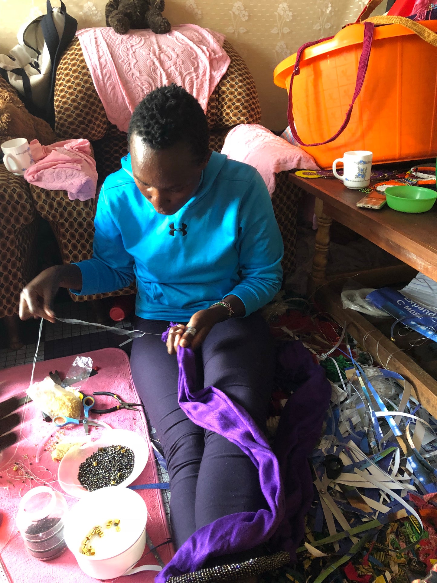 Wear the epitome of Kenya style with The Bintiah necklace. This necklace is handmade using colorful seed beads that are intricately and tightly wrapped around a solid piece fo make a stunning statement with any outfit. Black with colorful bead accent. Bintiah pictured making a product.