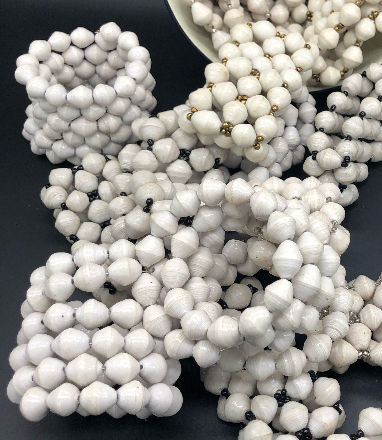 Hand crafted solid white wrap bracelet and solid white stretch bracelets with black, silver or gold bead embellishment Each bead individually rolled by hand from magazines. Stylish and fashionable for casual or dressy. Fair trade.