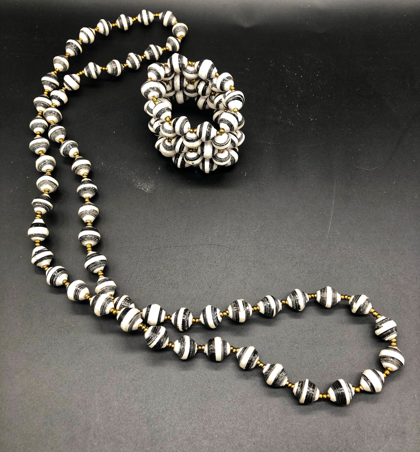 Hand crafted black and white medium length necklace and stretch bracelet set. Approximately 18" Long. Made from magazines. Each bead individually rolled by hand. Stylish and Fashionable for casual or dressy. Fair trade.