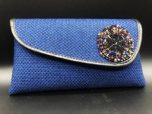 blue clutch with round beads on flap and black piping around edge