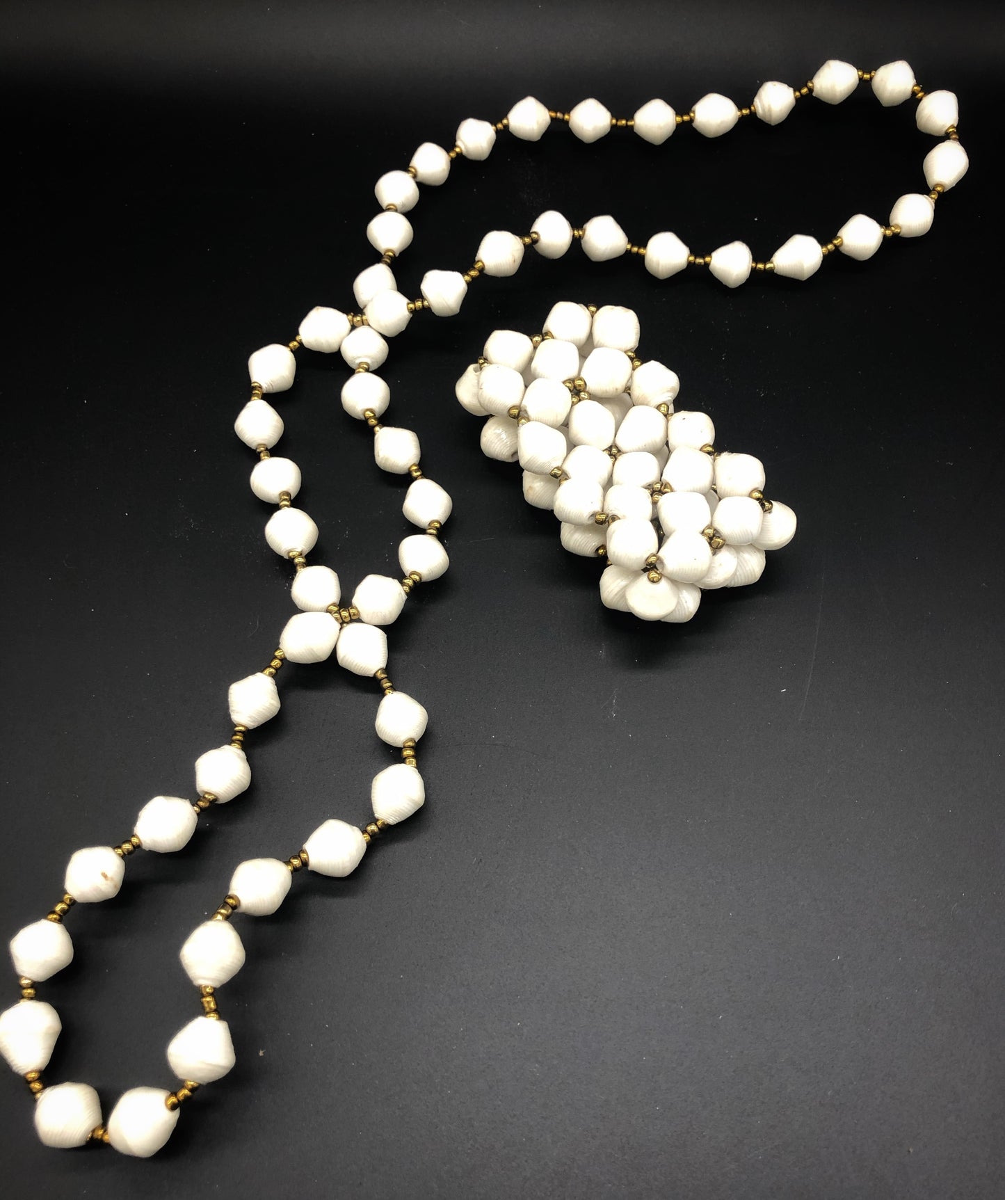 Hand crafted medium length white paper bead necklace approximate length 18” and stretch bracelet set with gold bead embellishment made from magazines. Each bead individually rolled by hand. Stylish and Fashionable for casual or dressy. Fair trade.