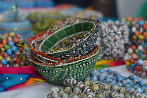 Fair trade hand crafted basket made from seed beads. Round shape bowl style. Stack of bowls in various colors