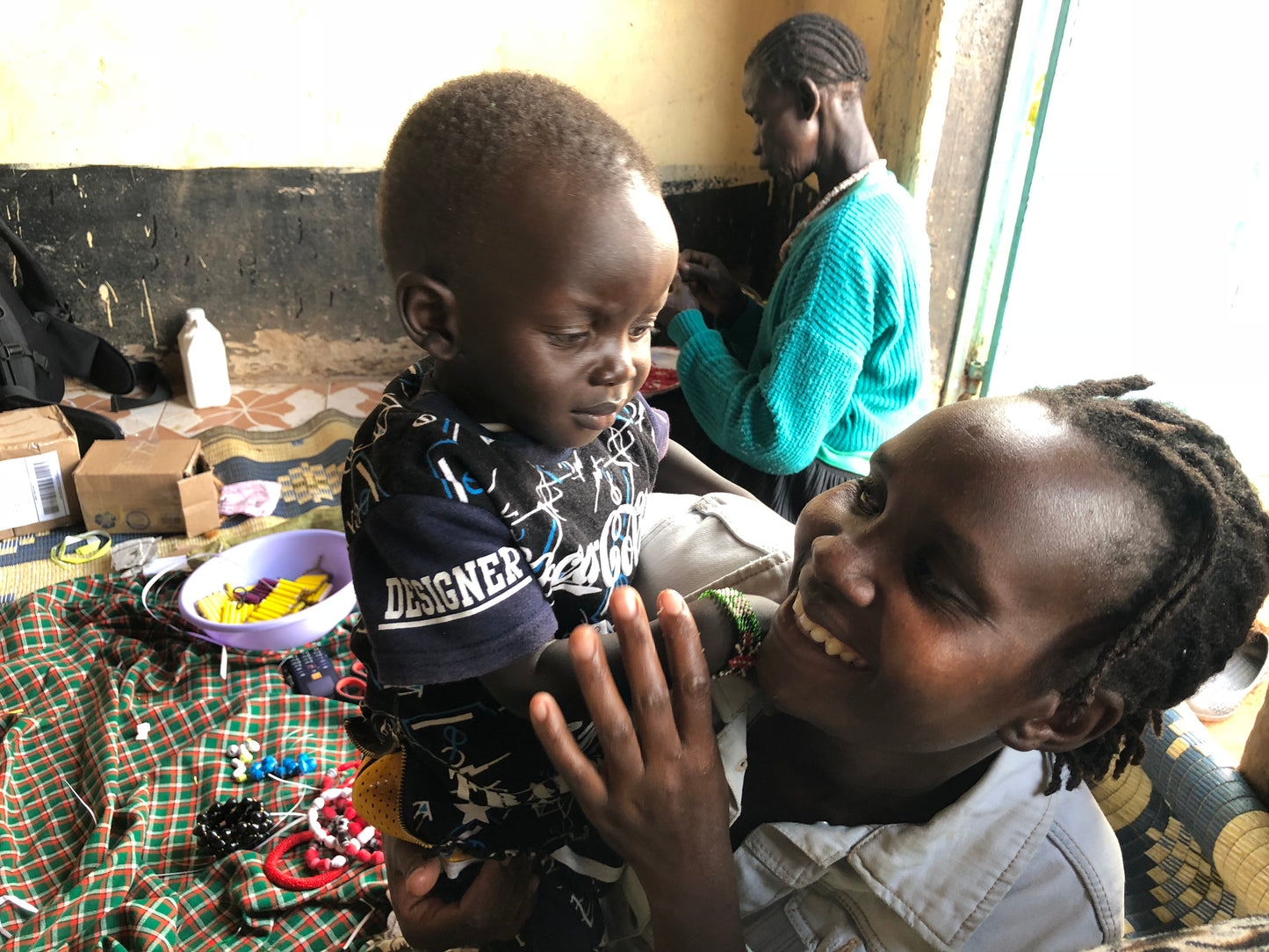 The Hellen necklace is named after one of our ladies whose photo you will find within this collection. Hellen was one of the original group of women we started working with. Hellen pictured with one of her children. 