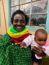 Load image into Gallery viewer, Patricia pictured in traditional Turkana dress with here youngest child Shari