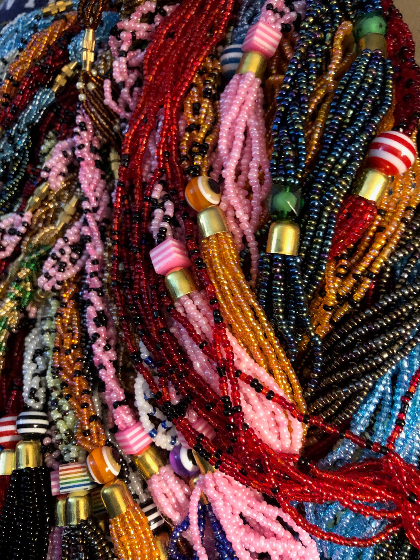 The Dinah necklace is named after one of our ladies whose photo you will find within this collection. The Dinah is a Fair trade hand crafted colorful seed bead necklace.  It is very delicate and classy.  Each necklace contains braided beads at top flowing into colorful hanging beads on the bottom. Each necklaces had solid color beads which are combined with colorful accent bead embellishment.     Slip over neck or easy open/close.