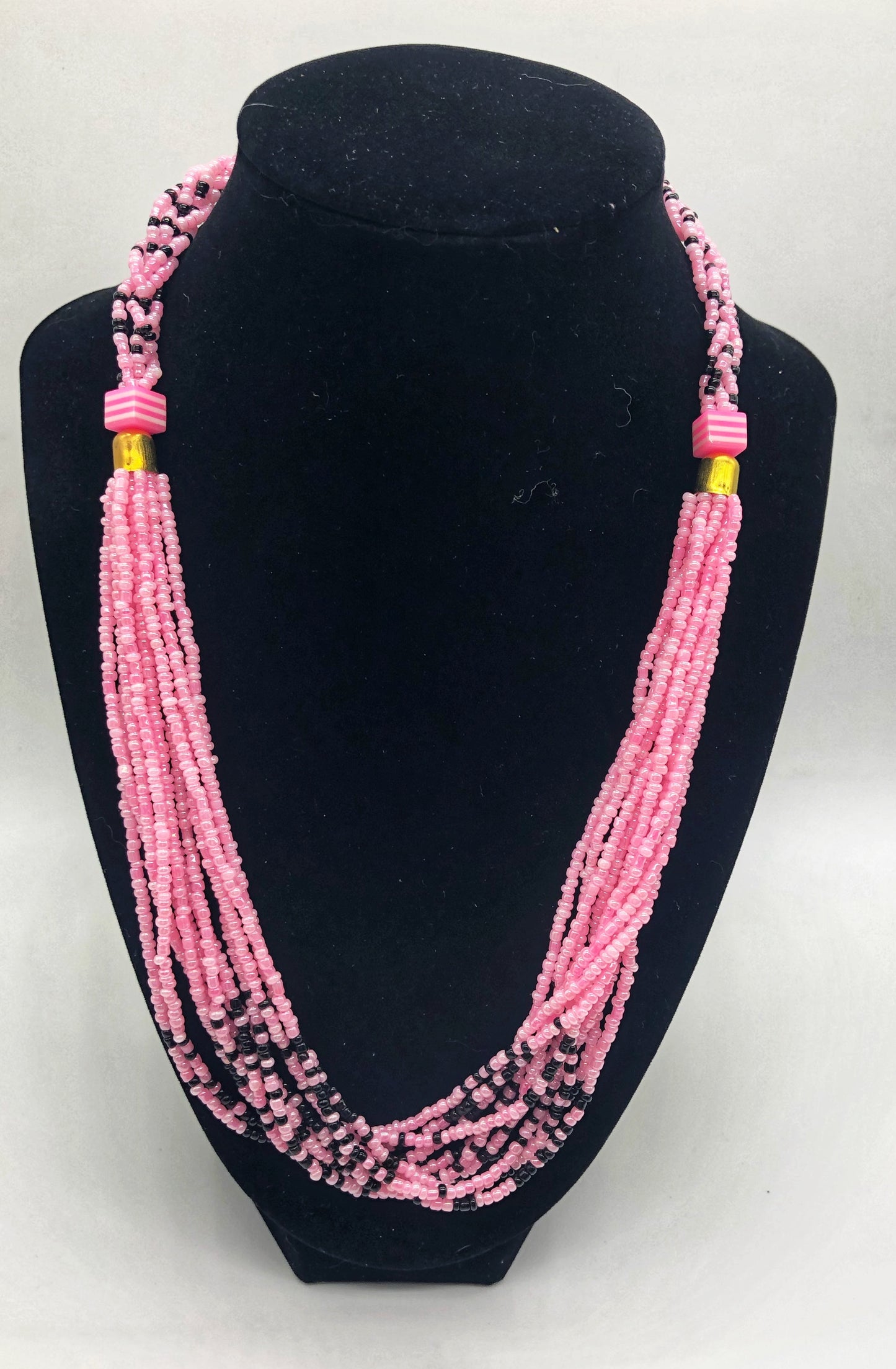 The Dinah necklace is named after one of our ladies whose photo you will find within this collection. The Dinah is a Fair trade hand crafted colorful seed bead necklace.  It is very delicate and classy.  Each necklace contains braided beads at top flowing into colorful hanging beads on the bottom. Each necklaces had solid color beads which are combined with colorful accent bead embellishment.     Slip over neck or easy open/close.