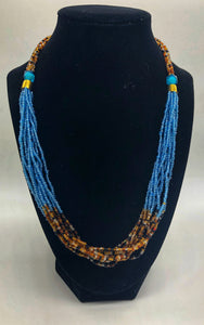 The Dinah necklace is named after one of our ladies whose photo you will find within this collection. The Dinah is a Fair trade hand crafted colorful seed bead necklace.  It is very delicate and classy.  Each necklace contains braided beads at top flowing into colorful hanging beads on the bottom. Each necklaces had solid color beads which are combined with colorful accent bead embellishment.     Slip over neck or easy open/close.