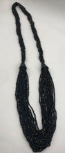 Load image into Gallery viewer, Make a statement with this beautiful handmade seed bead necklace.  Styled with braided beads around the neck flowing into a loose styled design. Black with gold bead accent