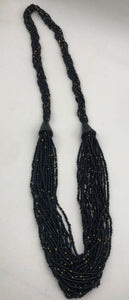 Make a statement with this beautiful handmade seed bead necklace.  Styled with braided beads around the neck flowing into a loose styled design. Black with gold bead accent