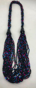 Make a statement with this beautiful handmade seed bead necklace.  Styled with braided beads around the neck flowing into a loose styled design. Black with pink and blue bead accent