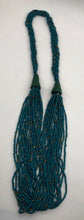Load image into Gallery viewer, Make a statement with this beautiful handmade seed bead necklace.  Styled with braided beads around the neck flowing into a loose styled design. Teal with gold bead accent