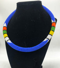 Load image into Gallery viewer, Wear the epitome of Kenya style with The Bintiah necklace.  This necklace is handmade using colorful seed beads that are intricately and tightly wrapped around a solid piece fo make a stunning statement with any outfit.   blue with colorful bead accent