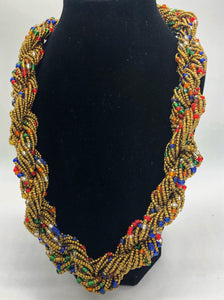 Stand out in style with this beautiful hand made braided style beaded necklace.  Approximately 18" end to end.   The Dorcas necklace is named after one of our ladies whose photo you will find within this collection. Gold with multi color accent