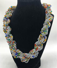 Load image into Gallery viewer, Stand out in style with this beautiful hand made braided style beaded necklace.  Approximately 18&quot; end to end.   The Dorcas necklace is named after one of our ladies whose photo you will find within this collection. Silver with multicolor accent
