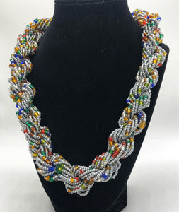 Stand out in style with this beautiful hand made braided style beaded necklace.  Approximately 18" end to end.   The Dorcas necklace is named after one of our ladies whose photo you will find within this collection. Silver with multicolor accent