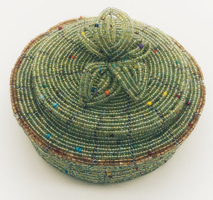 Fair Trade hand crafted basket made from seed beads. Round shape with lid. These baskets take 1 full day to create.  Pale green with gold accent around edge
