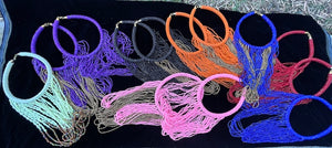 13 necklaces laid out on a black velvet cloth on the ground.  Chocker style necklace with long strands of beads.  Loops down and back up to chocker to connect. Cream, purple, black, orang, red, pink and royal blue solid and with gold beads shown. 