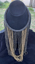 Load image into Gallery viewer, Black and gold necklace hanging on bust. Chocker with long strands of black and gold beads hanging down and looping back to connect to choker.