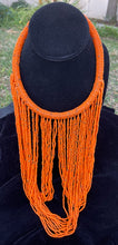 Load image into Gallery viewer, Orange necklace hanging on bust. Chocker with long strands of orange beads hanging down and looping back to connect to choker.