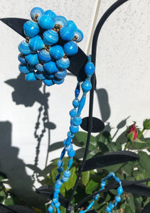 Long handmade paper bead necklace and stretch or memory wrap bracelet set blue color. Necklace is approximately 30” long and usually worn doubled. Bracelet is a wrap bracelet. Handcrafted from magazines. Fair trade. Weathered blue necklace and stretch bracelet pictured