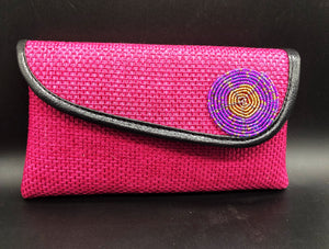 hot pink clutch with round beads around edge and black piping around edge of flap