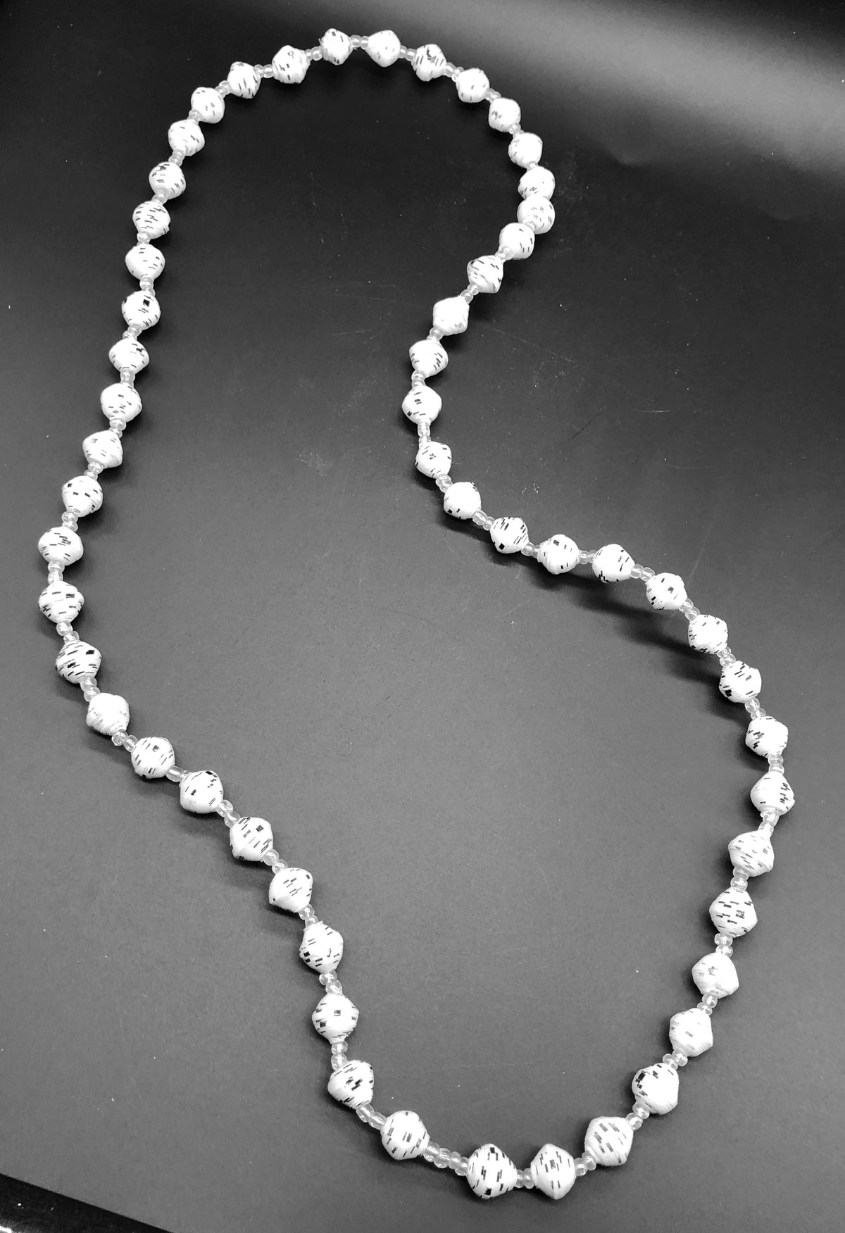 Hand crafted white with black accent paper bead necklace made from magazines. Each bead individually rolled by hand.  Stylish and Fashionable for casual or dressy. Fair trade.  Approximately 18" L
