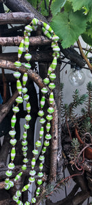 Handmade long length multicolor necklace made from magazines with accent seed beads in between. Each bead is hand rolled.Green and white pictured