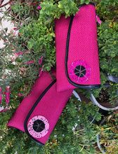 Load image into Gallery viewer, 2 Hot Pink clutches round bead embellishment and black piping on flap laying on green plants