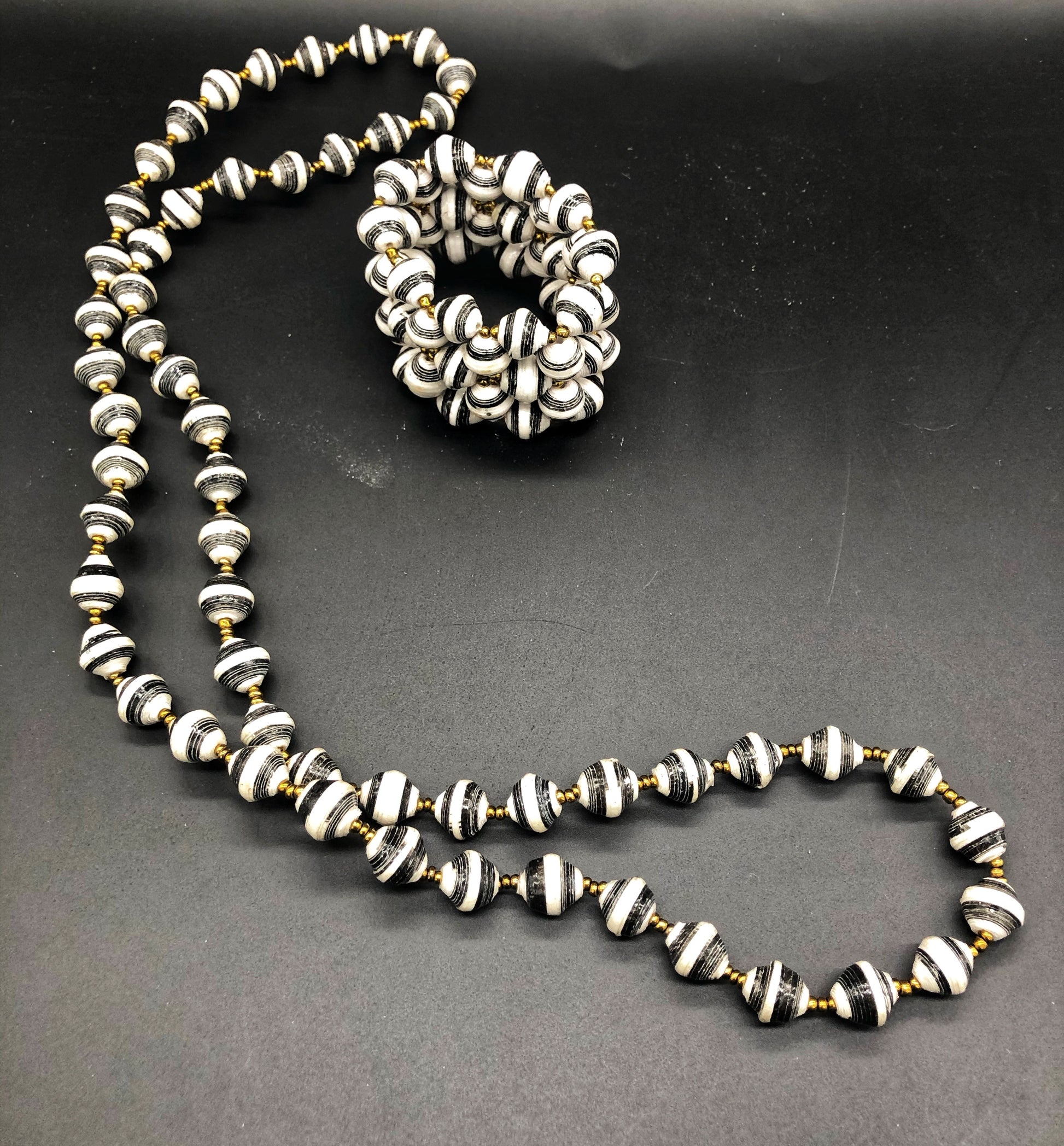 Hand crafted black and white medium length necklace and stretch bracelet set.  Approximately 18" Long. Made from magazines. Each bead individually rolled by hand.  Stylish and Fashionable for casual or dressy. Fair trade. 