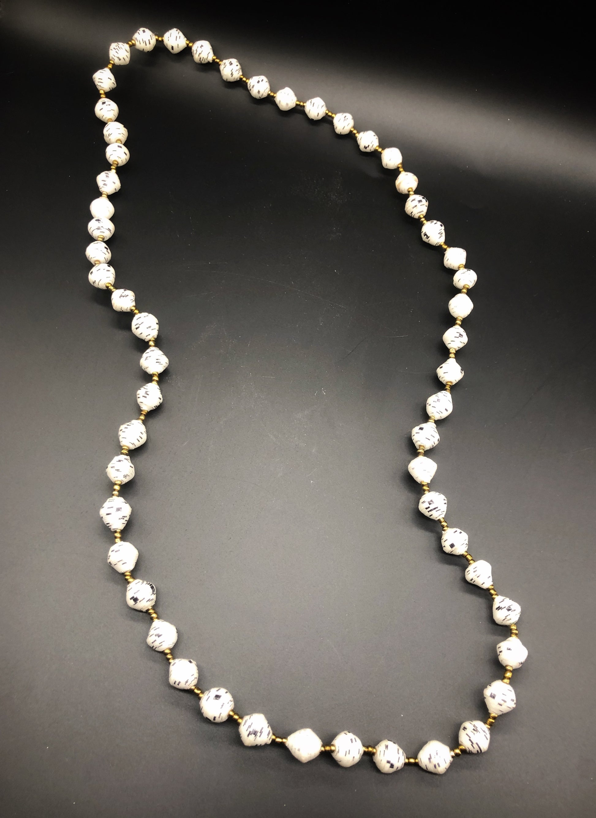Hand crafted white with black accent paper bead necklace made from magazines. Each bead individually rolled by hand.  Stylish and Fashionable for casual or dressy. Fair trade.  Approximately 18" L