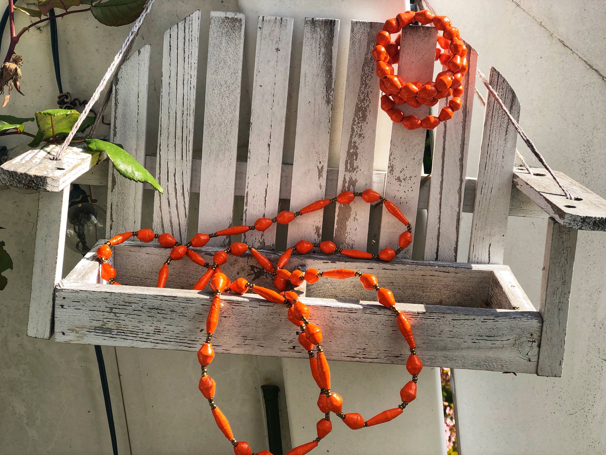 Long handmade paper bead necklace and memory wrap bracelet set orange color. Necklace is approximately 30” long and usually worn doubled. Bracelet is a wrap bracelet. Handcrafted from magazines. Fair trade. Color Orange necklace and wrap bracelet pictured.