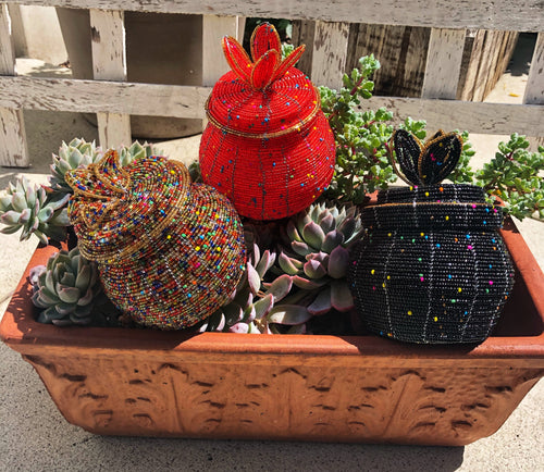 Fair Trade hand crafted basket made from seed beads in the shape of a jar with lid. Regular size baskets take at least a day to create.  Large baskets take 1 1/2 - 2 days to create. Red, Black and Gold Multi colors